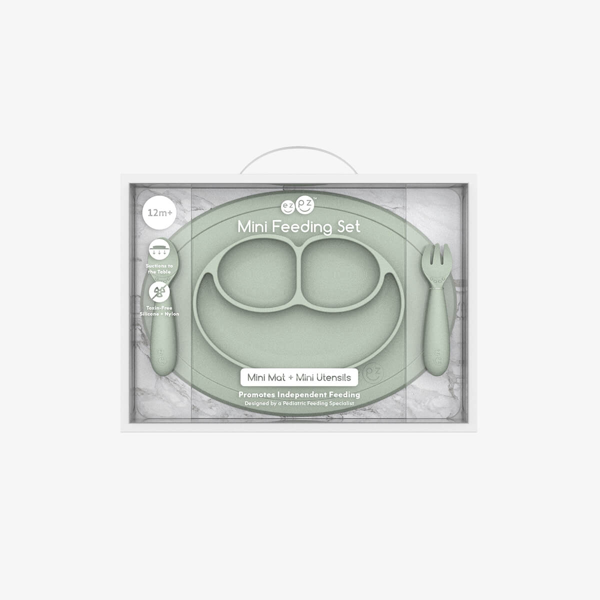 Green mini feeding set with plate, spoon, and fork in packaging on a white background